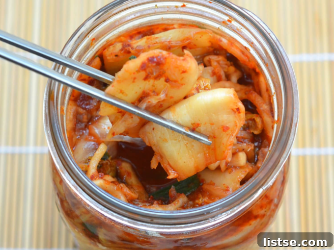 K-Food Wonders 4 A bowl of vibrant red Kimchi with napa cabbage leaves, garnished with sesame seeds and green onions