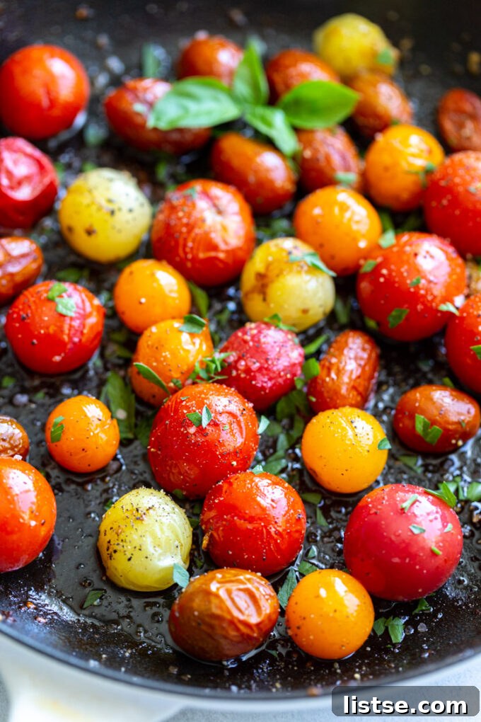 Fresh cherry tomatoes cooking and gently blistering in a hot skillet, creating a delicious aroma.