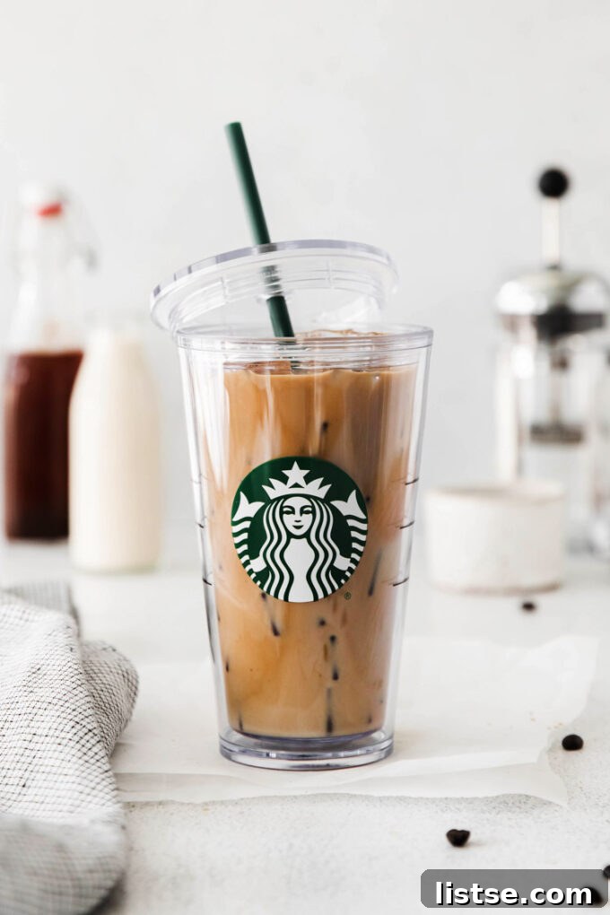 A tall glass of homemade Iced Brown Sugar Oatmilk Shaken Espresso, perfectly replicating the Starbucks version, with a lid resting beside it.