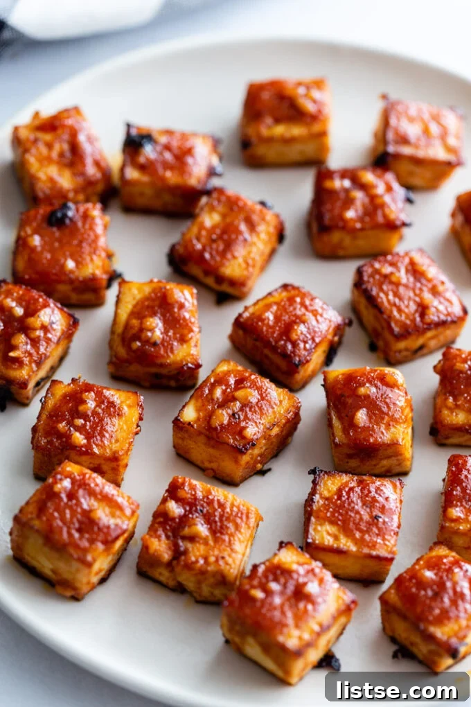 Close-up of perfectly glazed and caramelized BBQ tofu cubes on a plate.