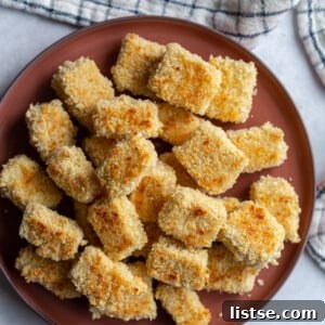 Panko crusted tofu cubes on a dark red plate, ready to be enjoyed.