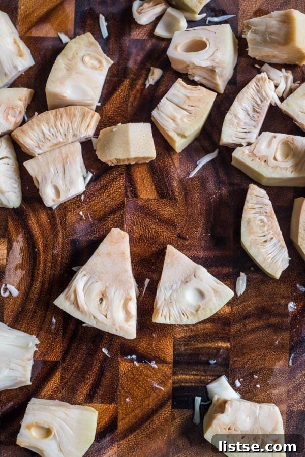 Freshly cut jackfruit on a wooden cutting board, revealing its fibrous texture.