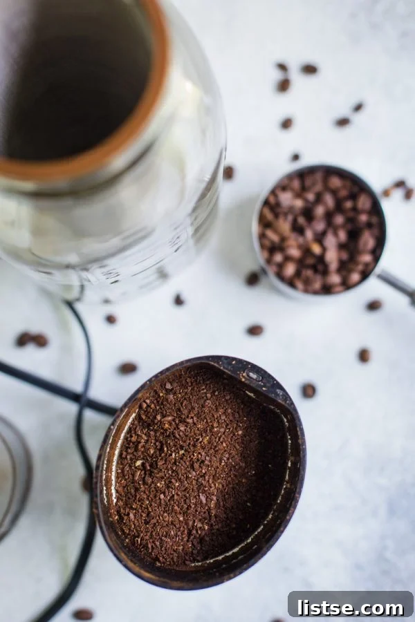 Close-up of coffee beans being meticulously ground in a traditional coffee grinder.