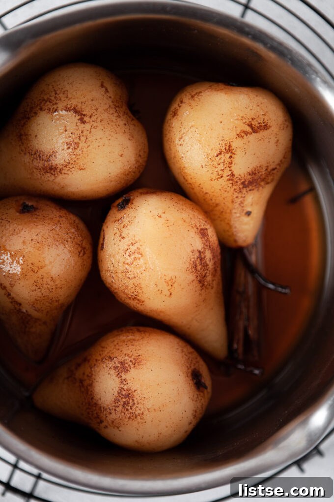 Y-Foods: A Tasty Exploration 3 Pears cooked in flavored syrup in a large pot, glistening and ready to be served. These resemble the elegant Yali pear.