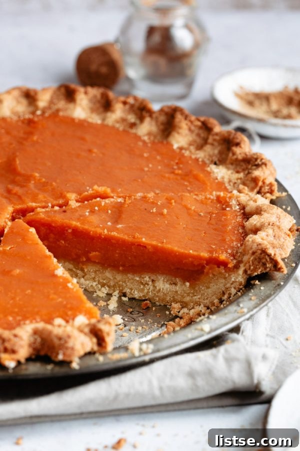 Y-Foods: A Tasty Exploration 4 Side shot of a sweet potato pie with a slice taken out, revealing its rich, creamy filling. This pie often uses 'yams' in its recipe title.