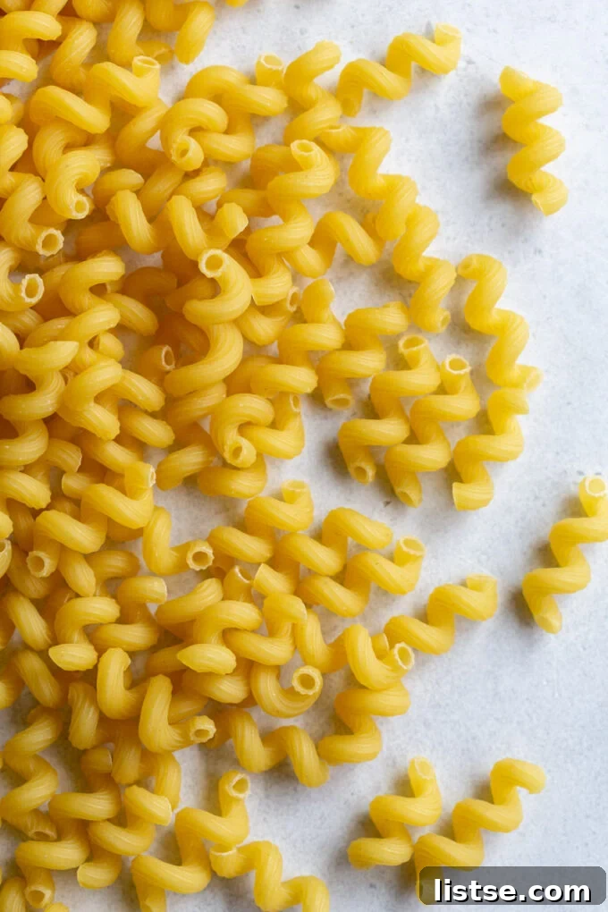 Velvety Cream Sauce Cavatappi 3 Uncooked corkscrew pasta noodles, showcasing the cavatappi shape.