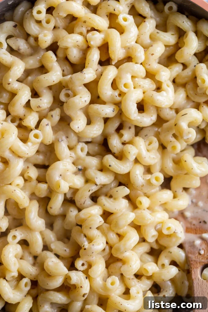 Velvety Cream Sauce Cavatappi 4 Creamy cavatappi pasta in a large skillet, garnished with fresh herbs.