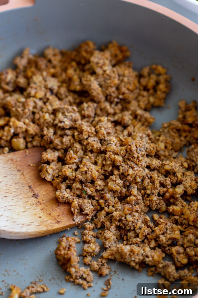Savory mushroom taco meat sizzling in a vibrant pink skillet, ready to be added to a delicious taco salad or other Mexican-inspired dishes.
