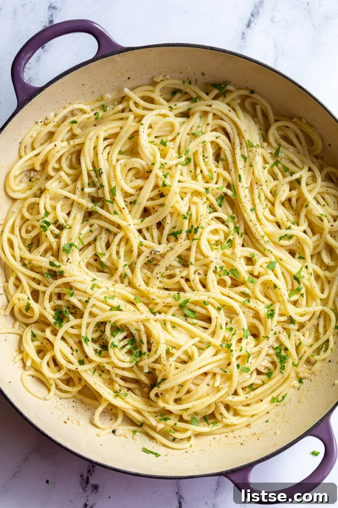 white wine pasta in a large skillet topped with fresh herbs