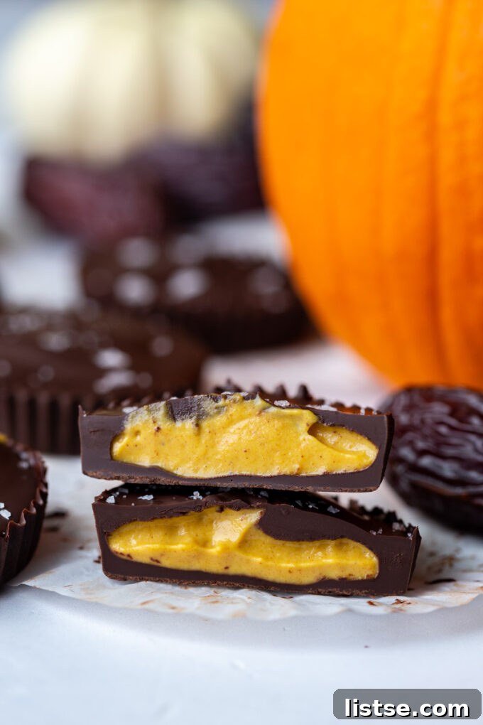 Date Sweet Pumpkin Peanut Butter Cups 2 Close-up of a whole Date Sweetened Pumpkin Peanut Butter Cup, showcasing its rich chocolate coating and a hint of the creamy filling.