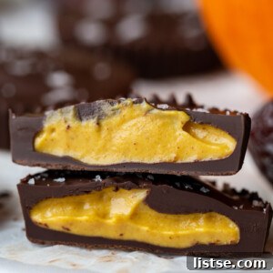 pumpkin peanut butter cup cut in half with a small pumpkin in the background