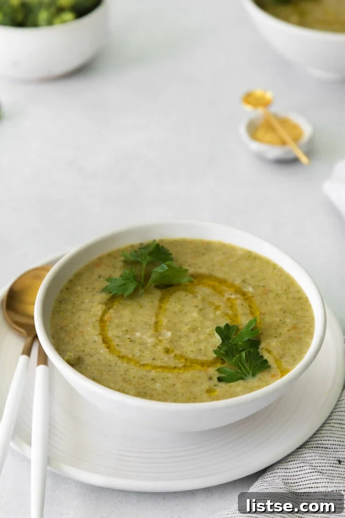 Velvety Vegan Broccoli Goodness 3 Vegan broccoli soup in a white bowl with a gold spoon, ready to eat