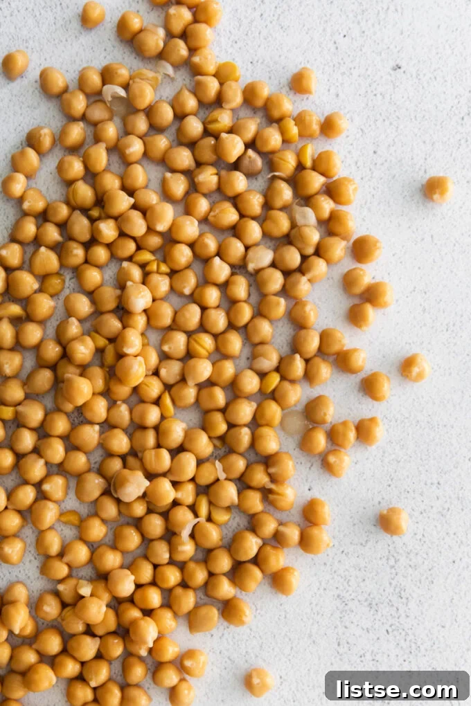 Cooked chickpeas spilled out on a tabletop, showcasing their texture