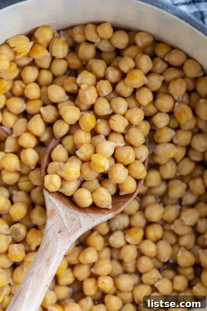Big pot of cooked chickpeas with a wooden spoon on the side, ready to be served