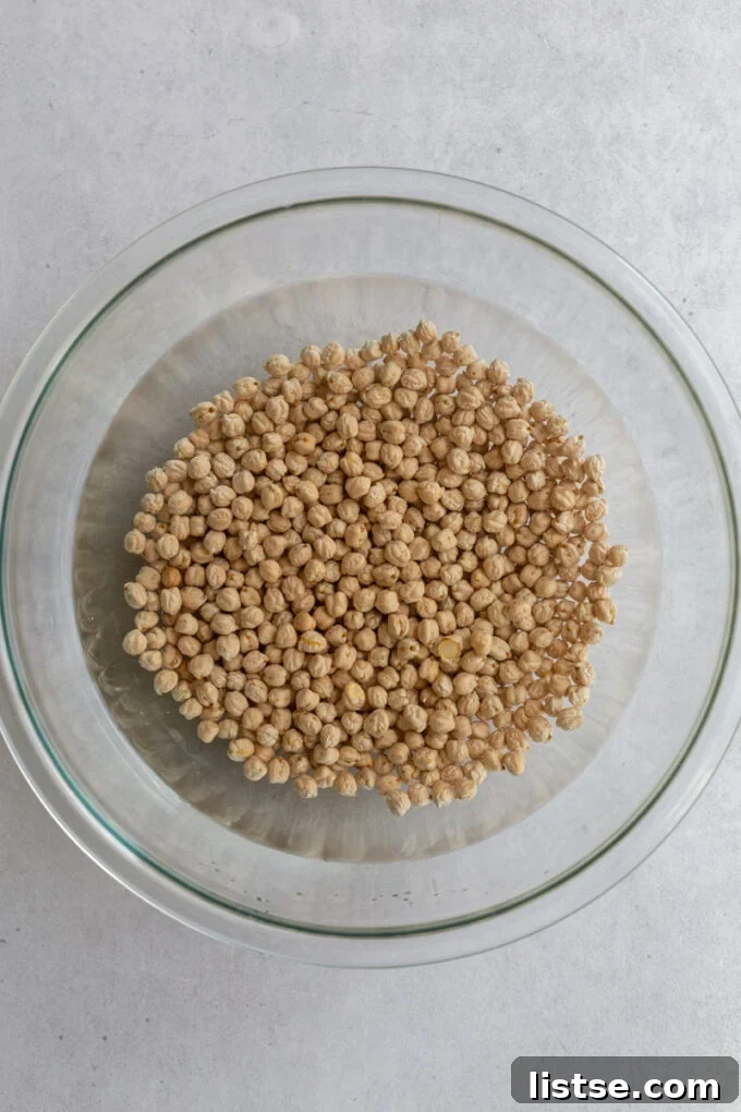 Glass bowl filled with chickpeas covered in water during the soaking process