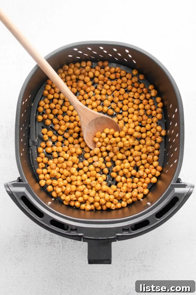 Crispy chickpeas in air fryer basket, seasoned and ready