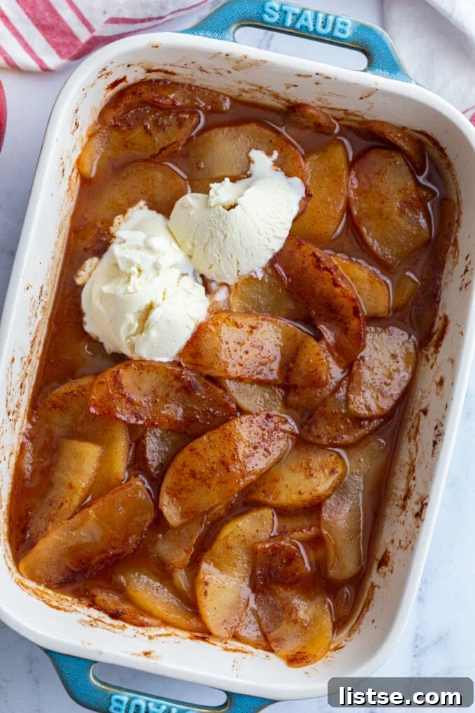 cinnamon apple slices in a baking dish and topped with vanilla ice cream