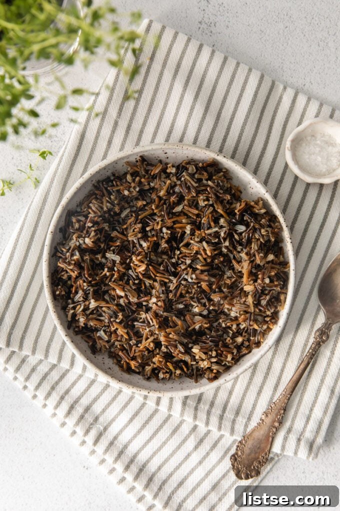 A generous serving of wild rice in a white serving bowl, ready for a meal.