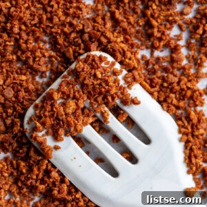 vegan bacon bits on a baking sheet with some on top of a spatula