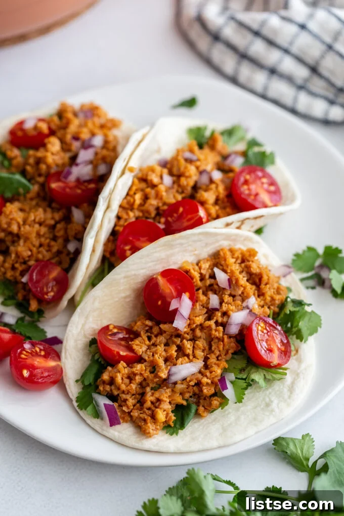 Unlocking TVP: A Comprehensive Guide to Versatile Plant-Based Meals and Perfect Tacos 7 A vibrant plate featuring three TVP tacos, artfully arranged and topped with fresh cilantro, juicy cherry tomatoes, and finely diced onions