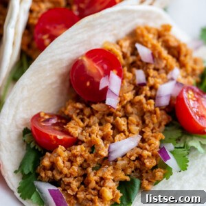 up close shot of a soft taco filled with tvp taco meat and fresh veggies