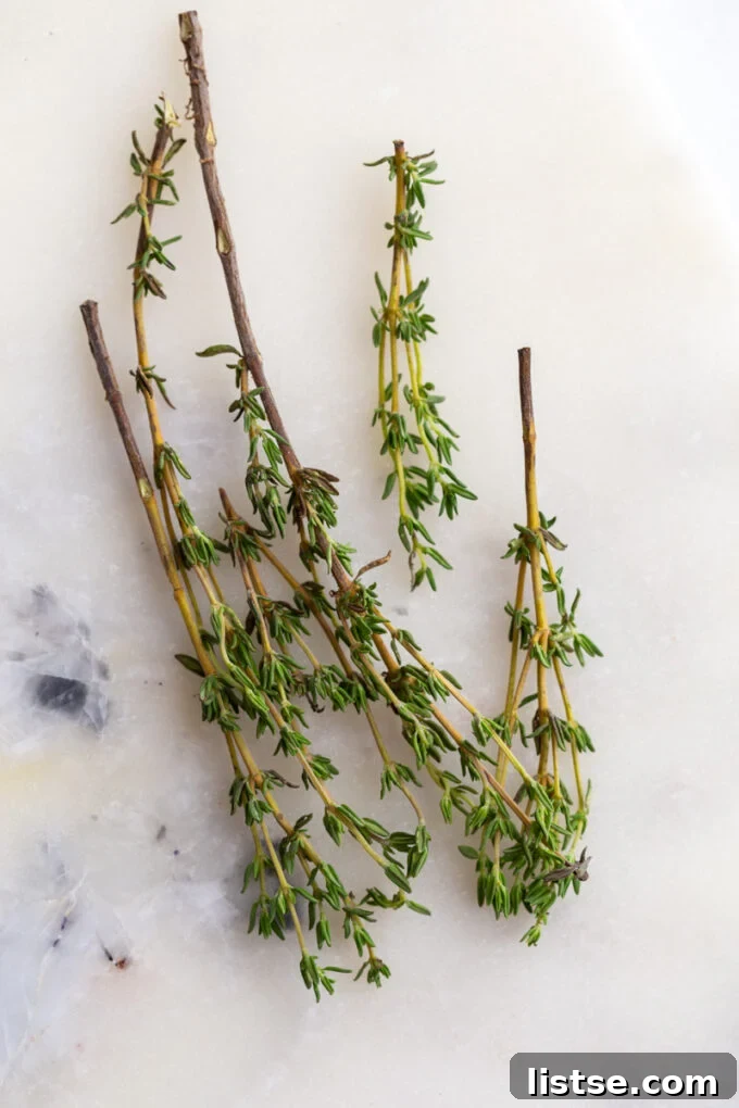 Top Thyme Alternatives 2 Fresh thyme sprigs resting on an elegant marble board, ready for culinary use.
