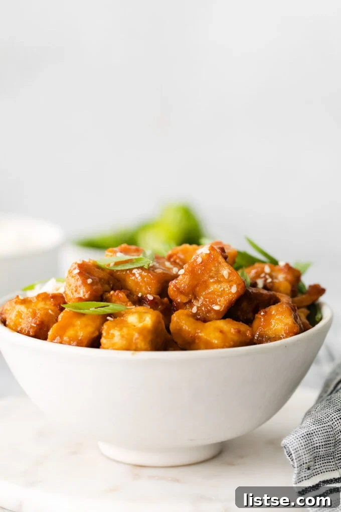 A white bowl filled with uncooked, pressed and cubed extra-firm tofu, ready for seasoning