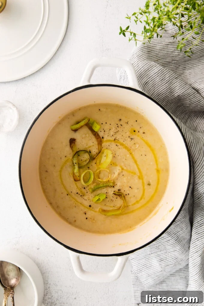 Vegan potato leek soup simmering in a large pot, ready for pureeing.