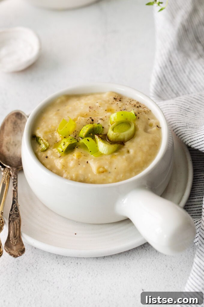 A bowl of creamy vegan potato leek soup, garnished with fresh chives, ready to be enjoyed.