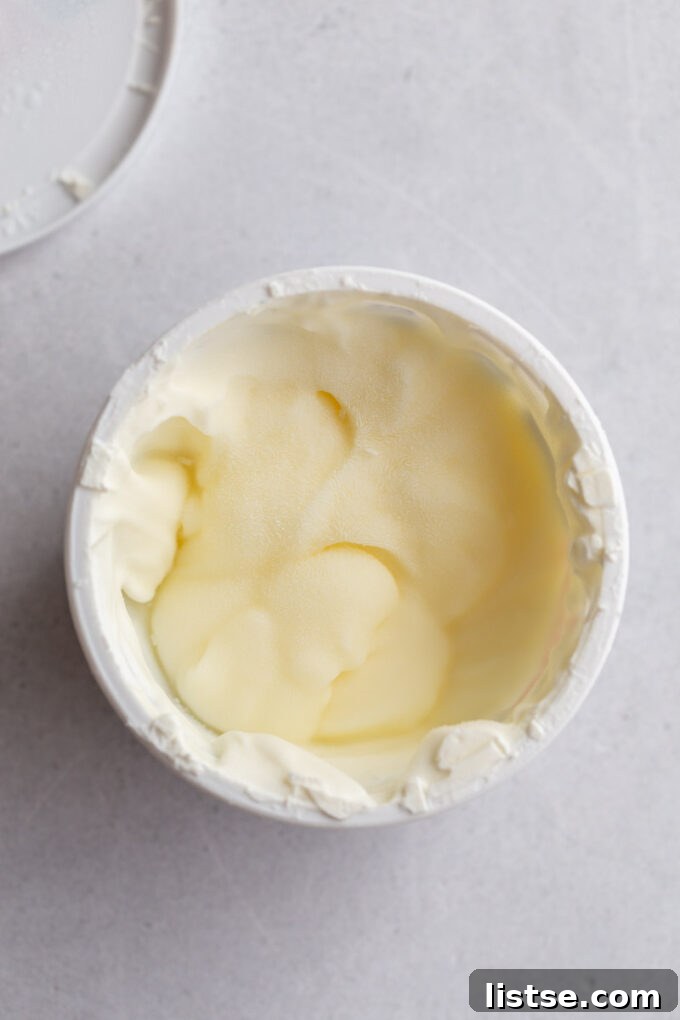 Frozen sour cream stored in its original container, showing one method of freezing.