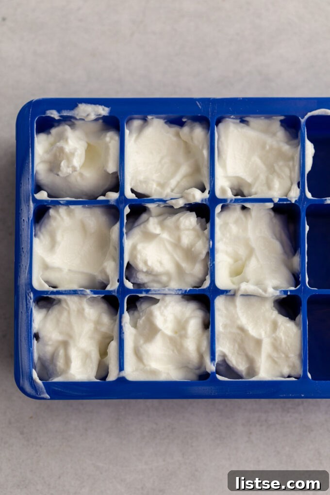 An ice cube tray filled with sour cream, demonstrating the portioning method for freezing.