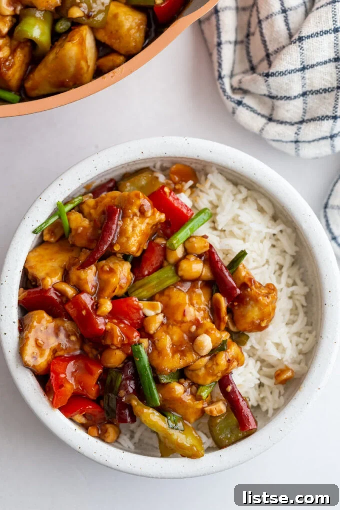 Individual serving of Kung Pao Tofu over white rice in a small white bowl