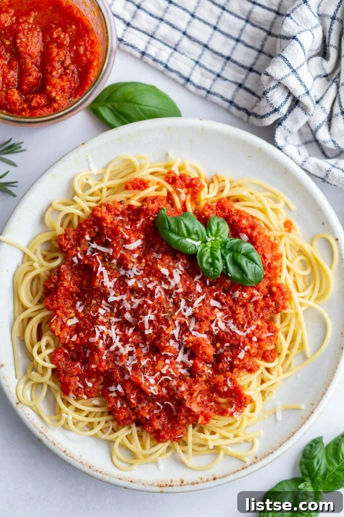 Pomodoro sauce generously coating a plate of spaghetti, garnished with fresh basil.