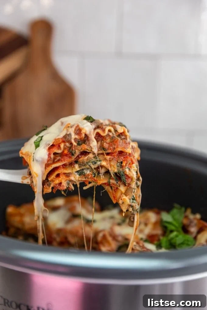 Effortless Vegetarian Crockpot Feasts 2 Serving lasagna directly from a crockpot, showcasing its cheesy layers and hearty texture.