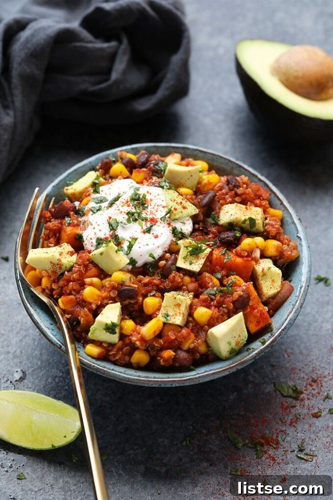 Effortless Vegetarian Crockpot Feasts 13 Mexican quinoa served in a bowl, topped with a dollop of sour cream and sliced avocado.