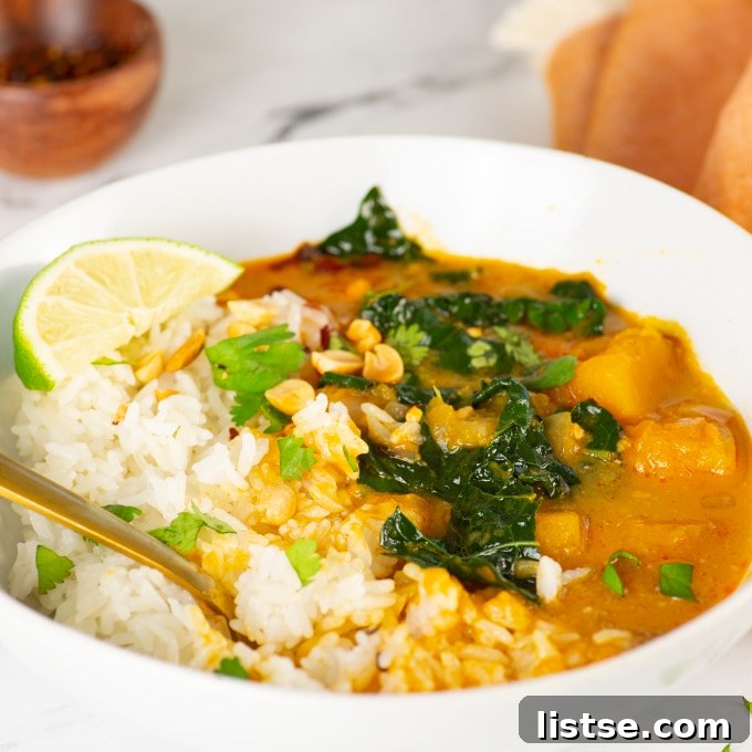 Effortless Vegetarian Crockpot Feasts 17 Rich butternut squash curry served in a white bowl, garnished with fresh herbs.