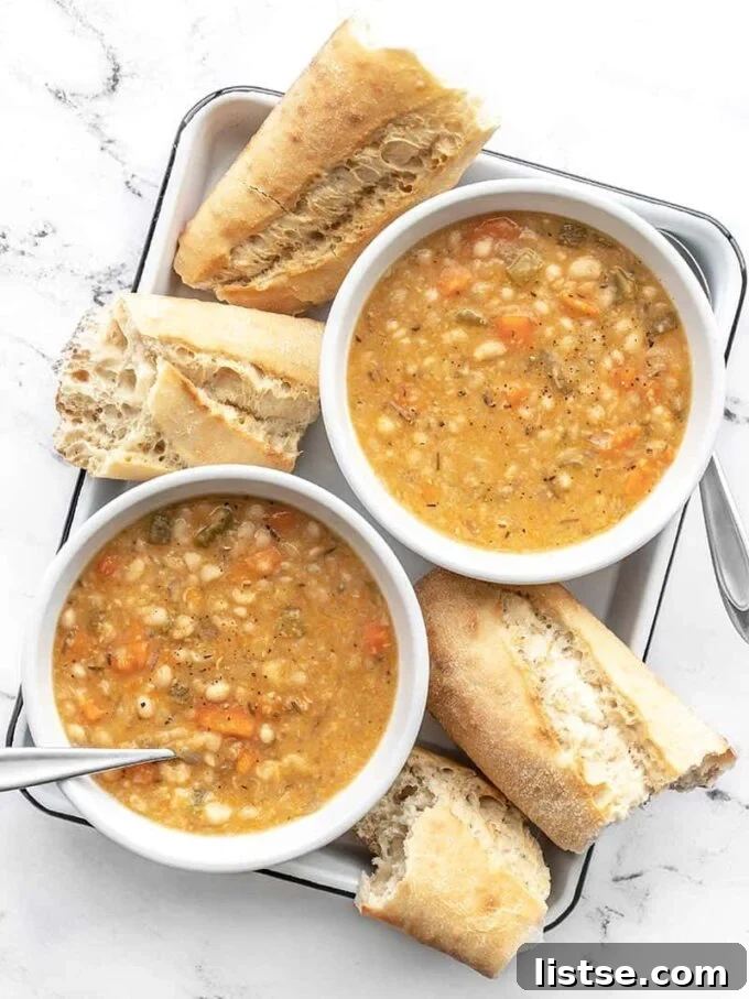 Effortless Vegetarian Crockpot Feasts 5 Warm white bean soup, garnished with fresh parsley, served alongside slices of French bread.