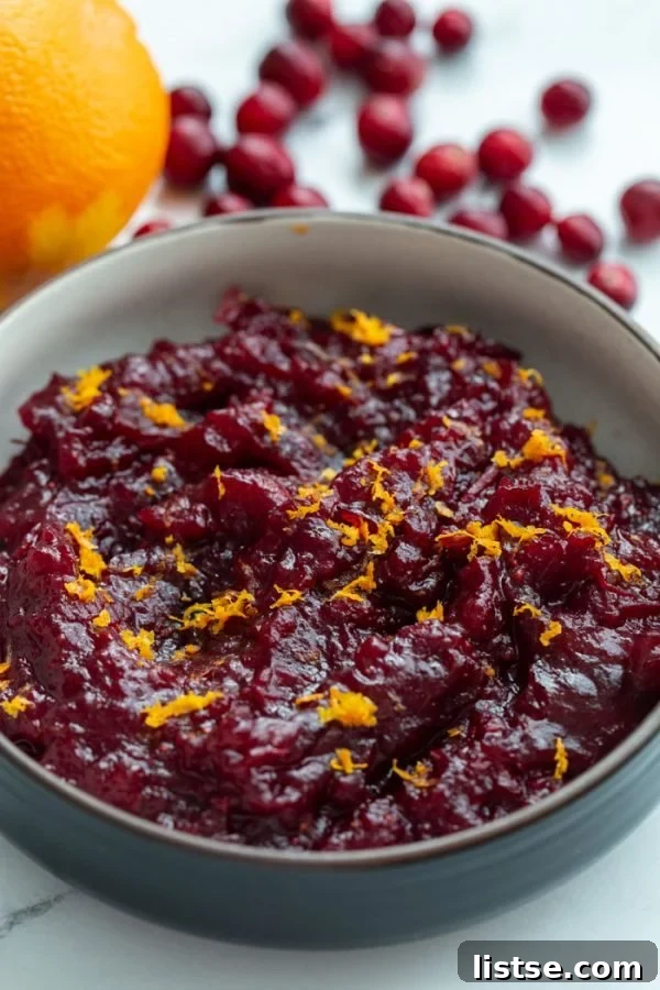 Effortless Vegetarian Crockpot Feasts 8 Homemade cranberry sauce, garnished with bright orange zest, served in a small dish.