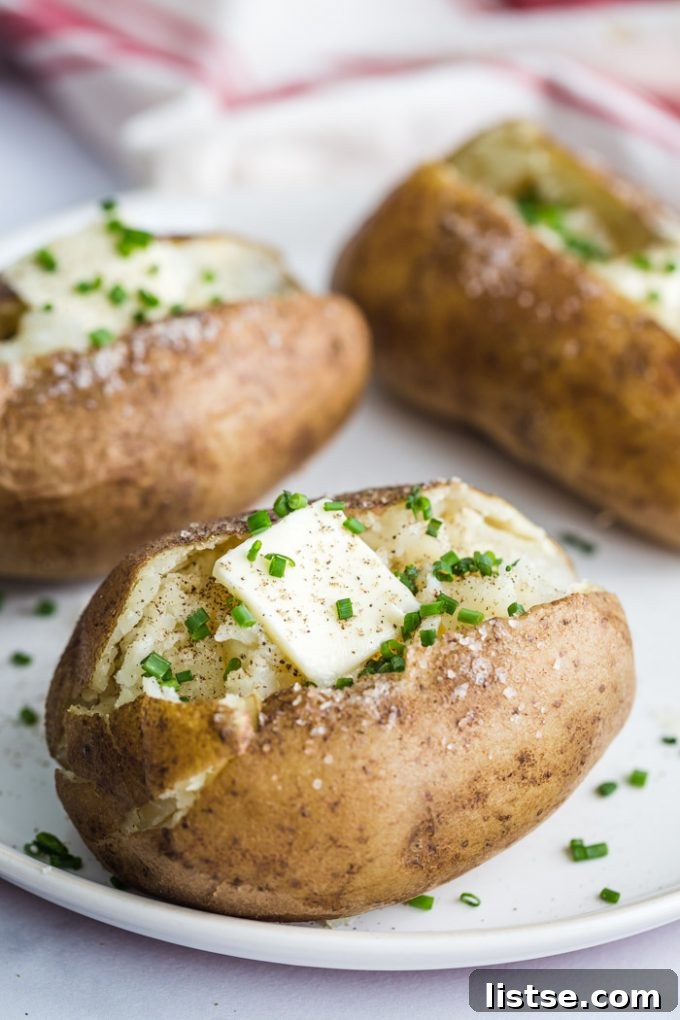 Beyond Chives: Flavorful Substitutions 3 A perfectly baked potato topped with a dollop of melting butter and a generous sprinkle of fresh, vibrant chives.