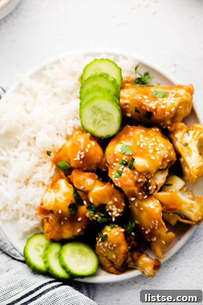 Delicious sesame cauliflower served with a side of white rice, making a complete meal.