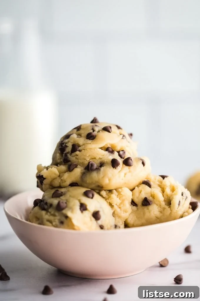 A tempting bowl of rich, safe-to-eat vegan edible cookie dough, garnished with chocolate chips and ready to be enjoyed by the spoonful.