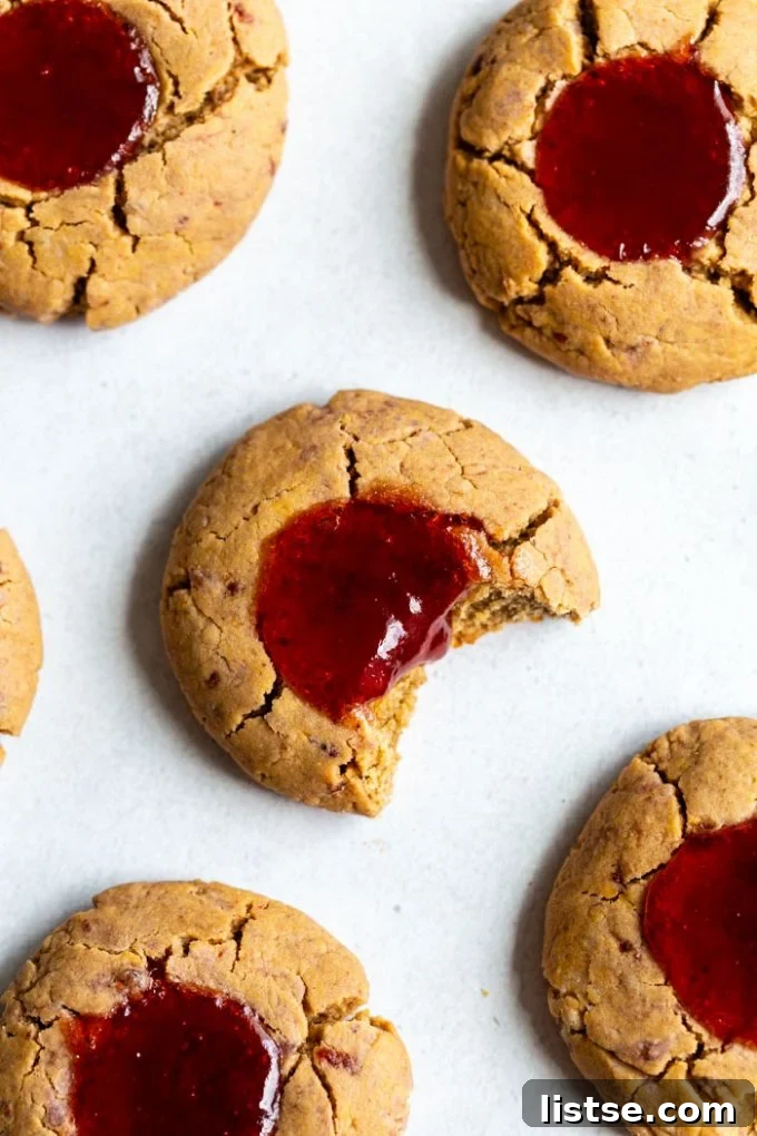 Delicious vegan jam thumbprint cookies filled with vibrant fruit preserves, freshly baked and ready to enjoy.