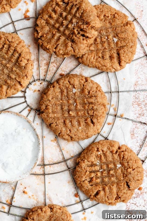 Freshly baked vegan peanut butter cookies featuring the classic criss-cross pattern, cooling on a wire rack.