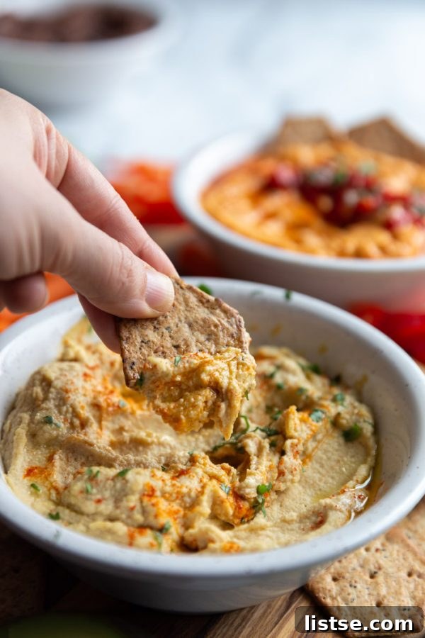 Inspired Chickpea Meals 11 A close-up of a variety of homemade hummus dips in small bowls, garnished creatively, showcasing different flavor variations.
