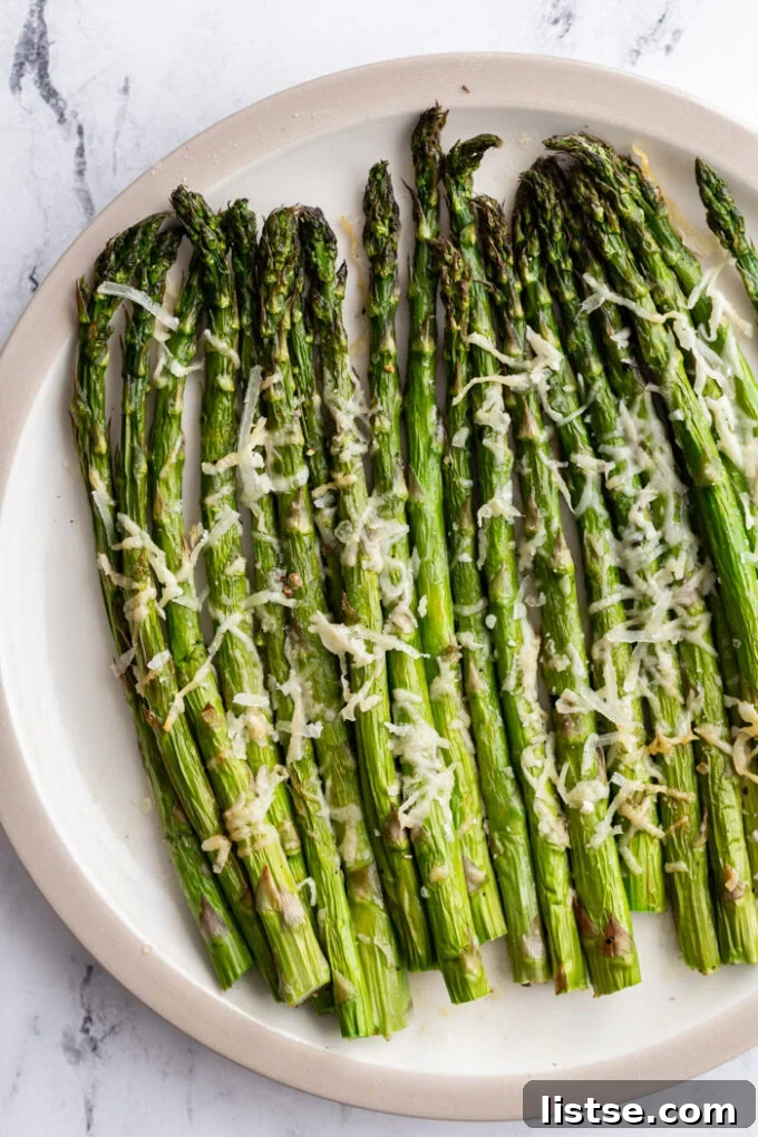 Appetizing A-Foods: A Culinary Exploration 9 air fryer asparagus topped with parmesan cheese on a serving plate