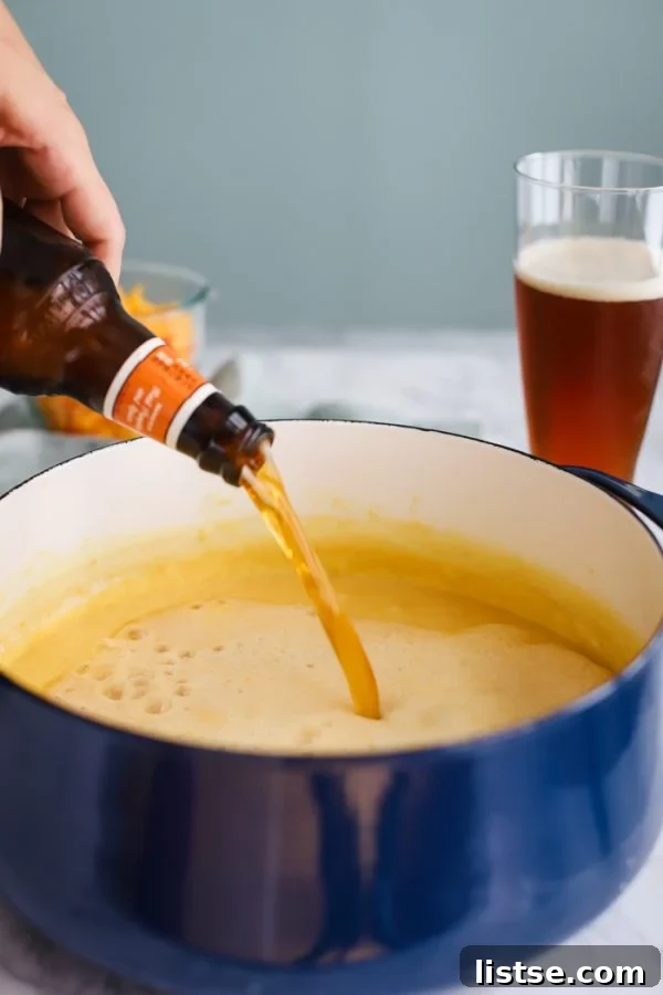 A rich and creamy beer cheese soup, garnished with fresh herbs.