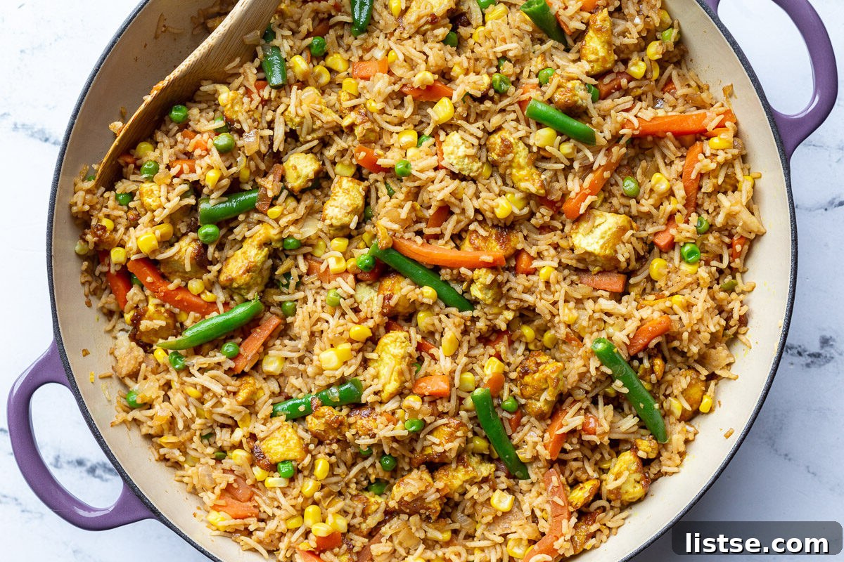 Ultimate Tofu Fried Rice 2 Flavorful Tofu Fried Rice with colorful vegetables in a large purple skillet, ready to be served.
