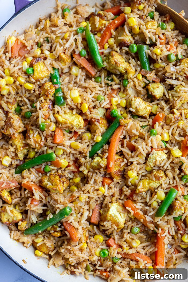 Ultimate Tofu Fried Rice 6 Tofu Fried Rice with vegetables in a large purple skillet, perfectly cooked and ready to serve.