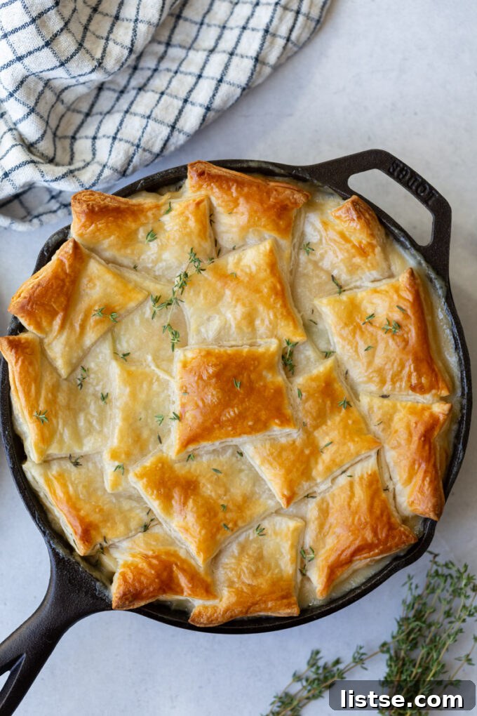 Hearty Chickpea Puff Pastry Pie 3 Delicious pot pie in a skillet, adorned with a golden, flaky puff pastry crust