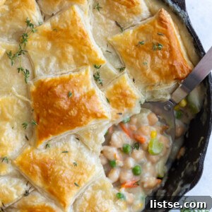 chickpea puff pastry pot pie being served out of a cast iron skillet
